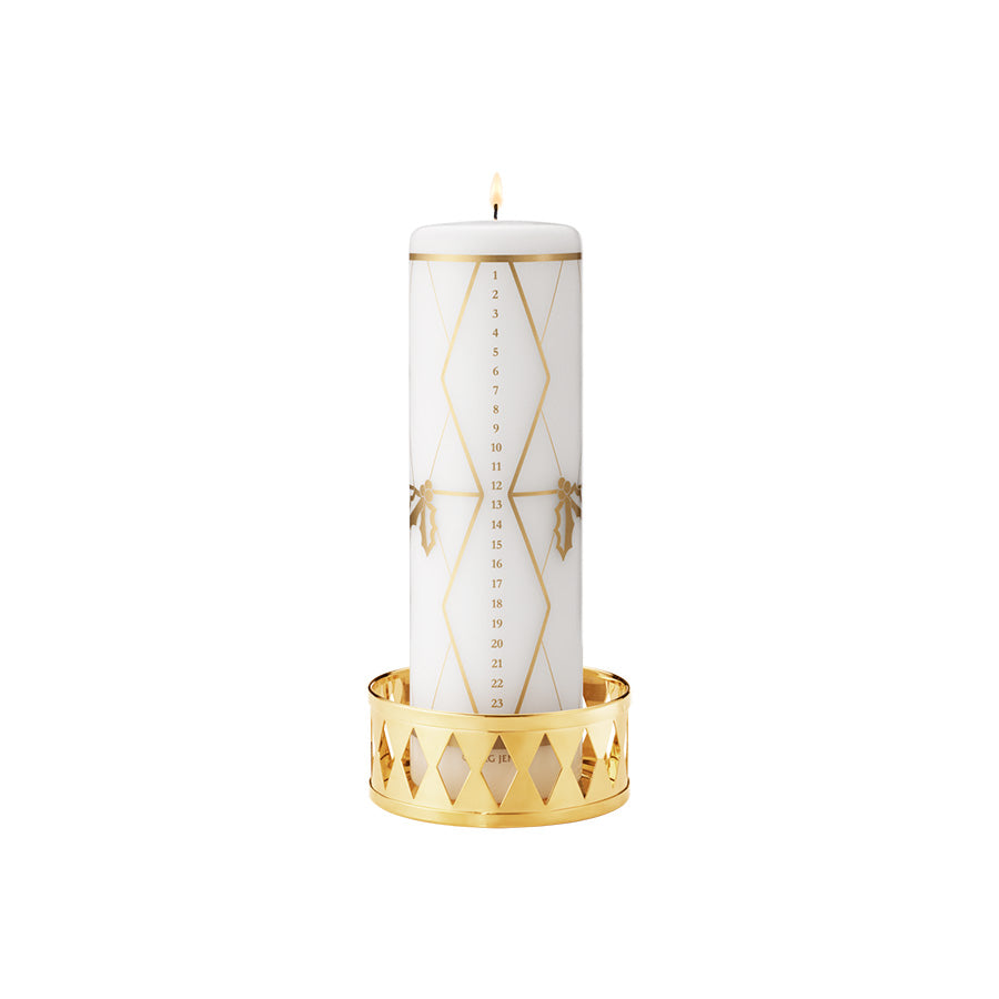 Georg Jensen kalenderlys 2026 med gullfargede motiver av kristtorn og tromme
