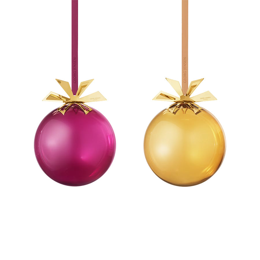 Georg Jensen CC 2025 Glasskuler 2pk - Sett med to munnblåste glasskuler i gull og burgunder med festlig metallstjerne.