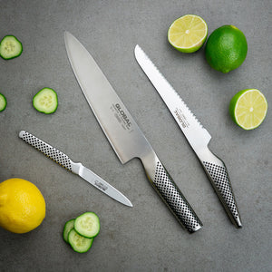 GLOBAL Knivsett 3 kniver – tre kniver fra GLOBAL til hakking, brødskjæring og presis skrelling, vist med sitron og agurk