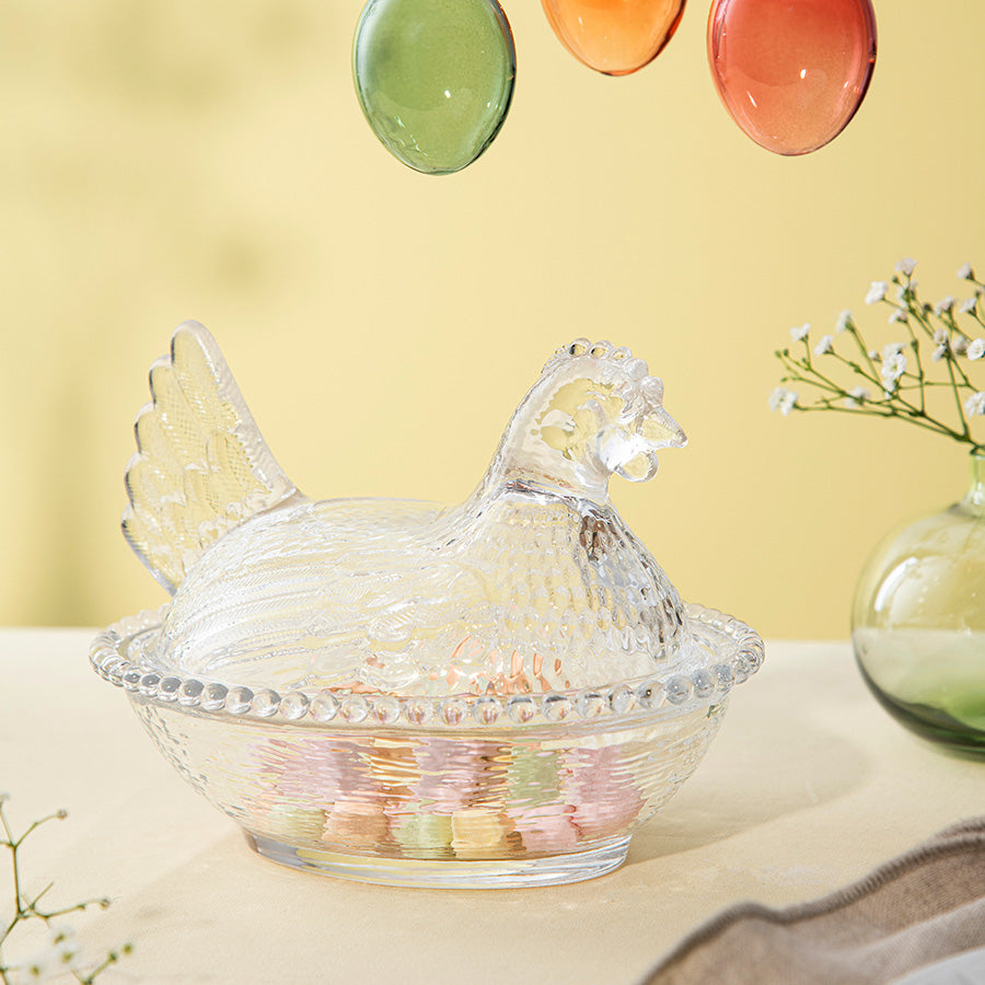 Hadeland Glassverk klar glass verpehøne skål, dekorativ påskeskål med fargerike påskeegg over bordet.