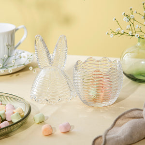 To Hadeland Glassverk påskeegg, ett med kaninører, presentert med søtsaker på et bord, perfekt for påskefeiring.