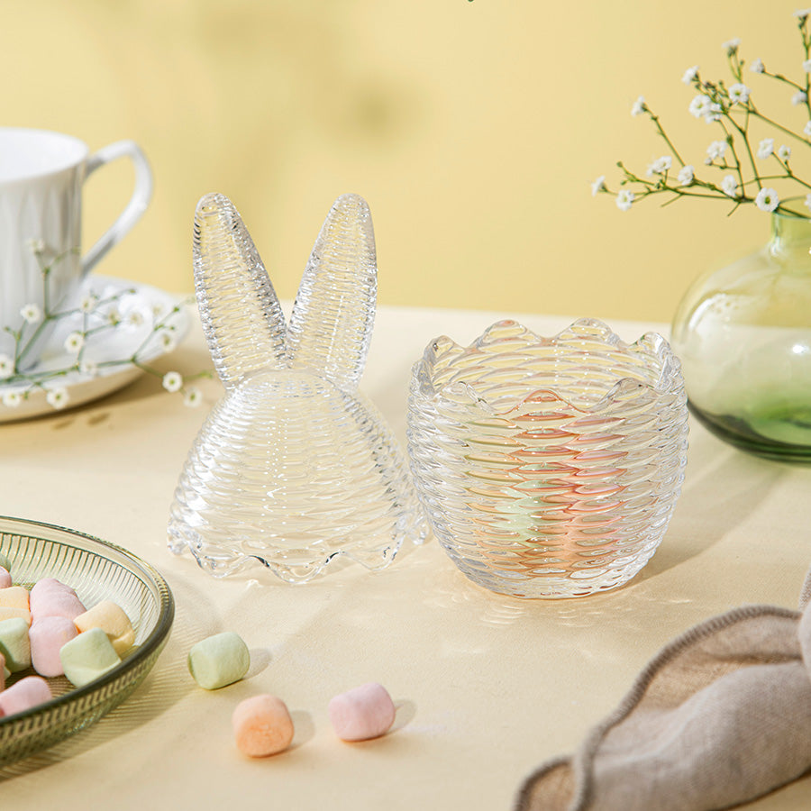 To Hadeland Glassverk påskeegg, ett med kaninører, presentert med søtsaker på et bord, perfekt for påskefeiring.