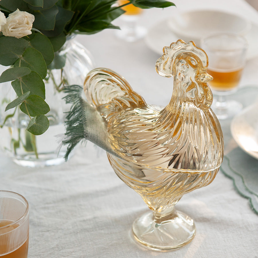 Hadeland Glassverk glasshane med lokk, et dekorativt element på et festbord.