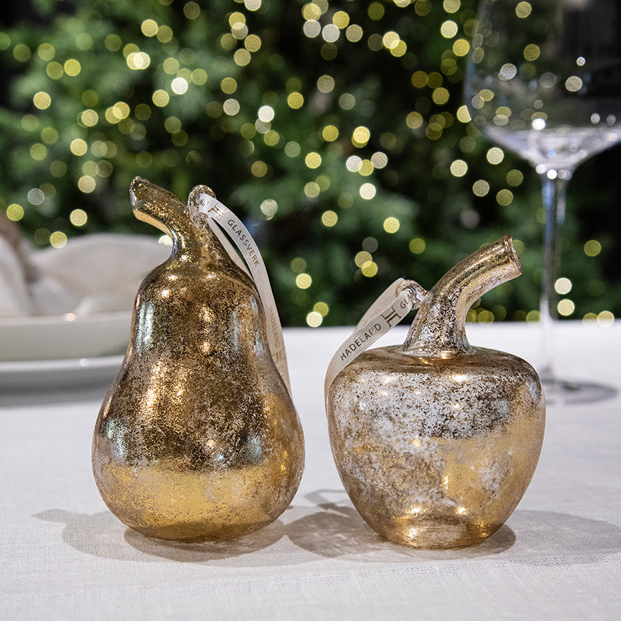 Elegante glassfrukter fra Hadeland Glassverk, inkludert pære og eple med metallisk glans, ideelle for juledekorasjon.