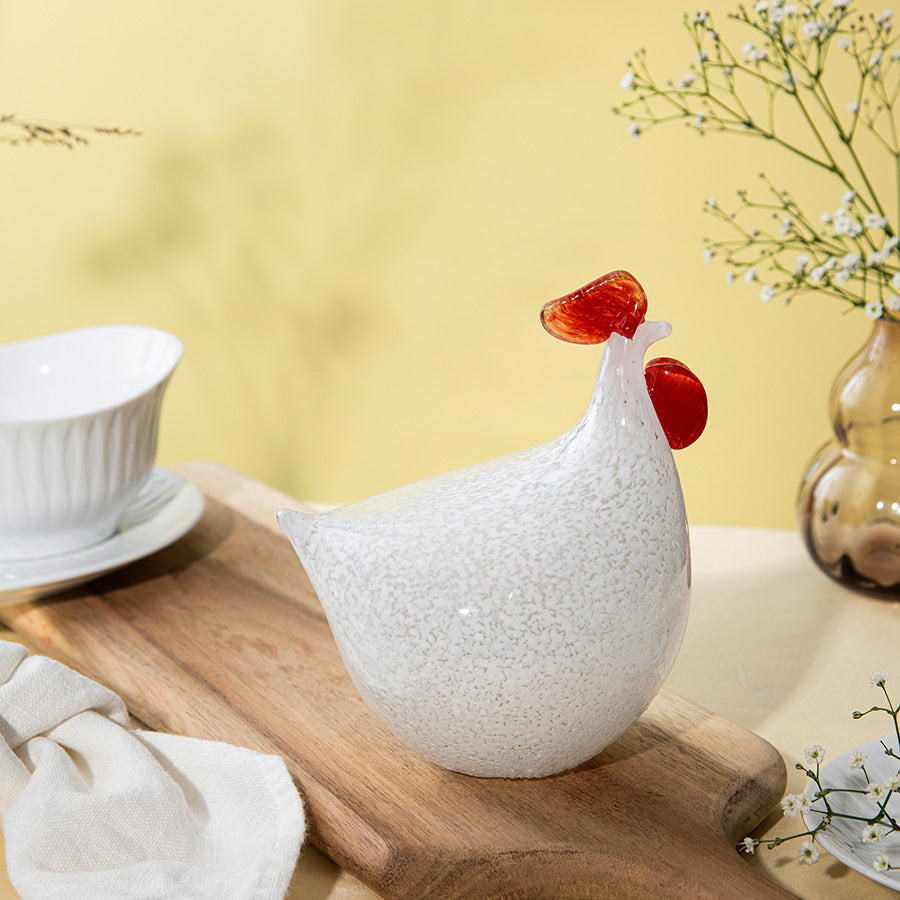 Hadeland Glassverk høne i kunstglass, plassert på en treplate, med vakre detaljer og en moderne stil. Ideell for dekorasjon til påske.