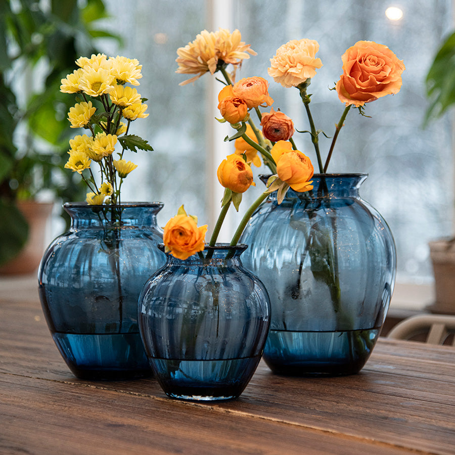 Bilde av Hadeland Glassverk Emily Vase 17,5cm Blå Optikk med enkle blomster, ideelt for borddekorasjon i moderne interiør.