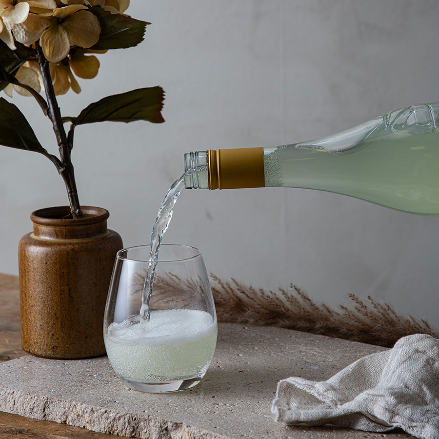 Hadeland Glassverk Odyssé Vannglass 39cl 6pk. Et vannglass fylt med boblevann som helles fra en flaske, ideelt for enhver anledning.