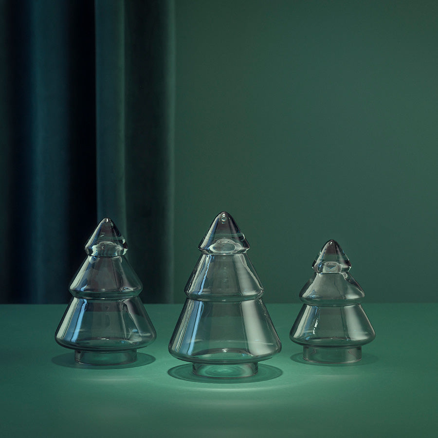Tre forskjellige størrelser av Gran Glasstre fra Hadeland Glassverk, i klart glass, som gir et stemningsfullt lysspill, ideelt for dekorasjon.