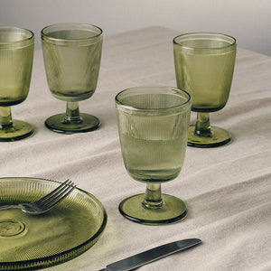 Fire Hadeland Glassverk Siri glass med stett i grønn farge på et dekket bord, perfekt til både hverdag og fest.