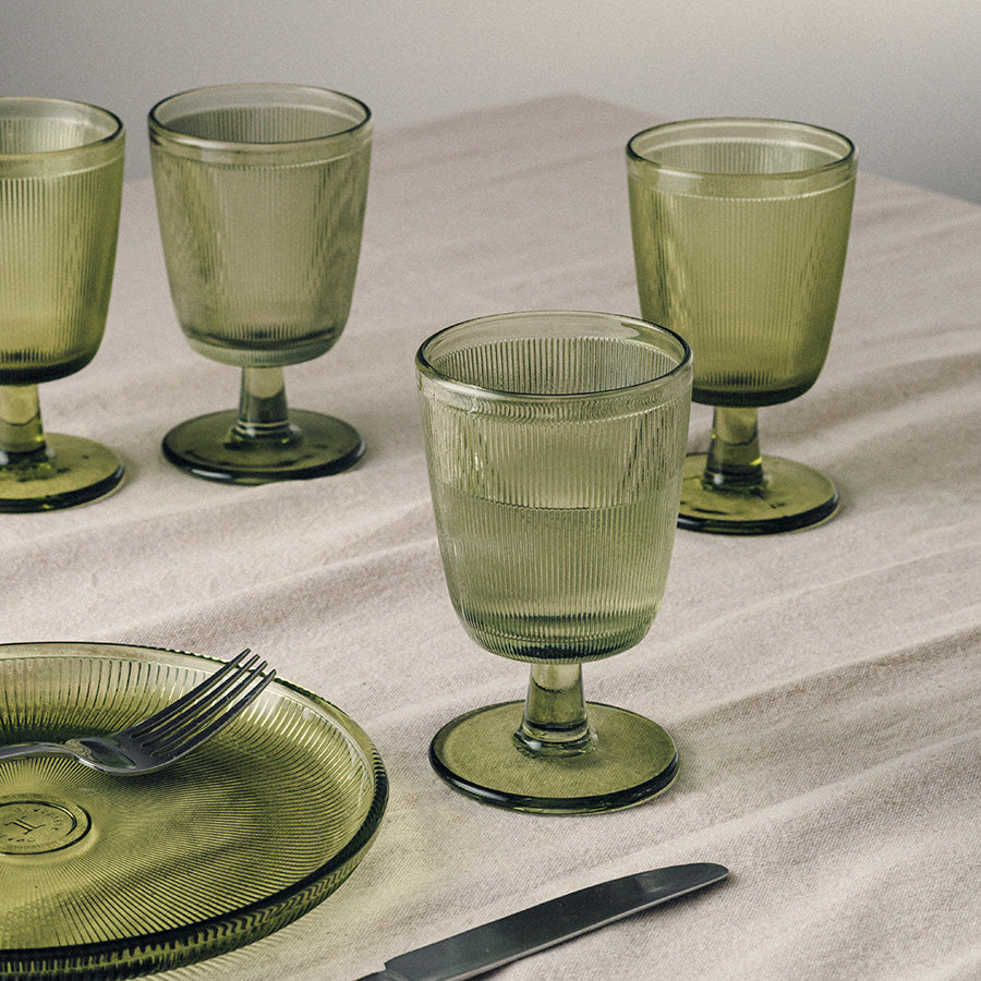 Fire Hadeland Glassverk Siri glass med stett i grønn farge på et dekket bord, perfekt til både hverdag og fest.