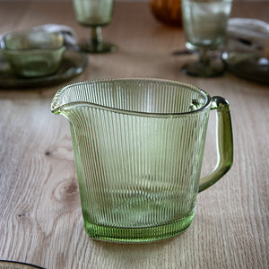 Hadeland Glassverk Siri Mugge 1l Grønn – Grønn mugge med ikoniske riller, plassert på et bord, ideell for både hverdag og selskap.