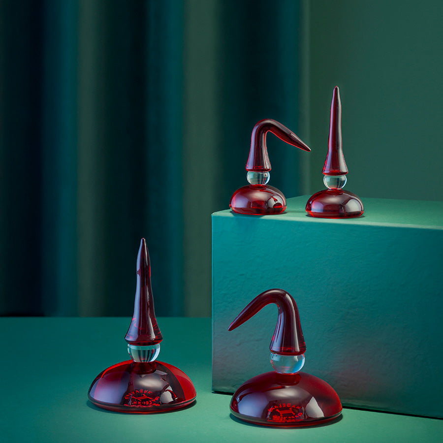 Samling av Hadeland Glassverk HG Nisse St Nikolas Far, 11,5 cm Rød, vist i et stilfullt miljø, inkludert flere glassfigurer som representerer norsk julepynt.