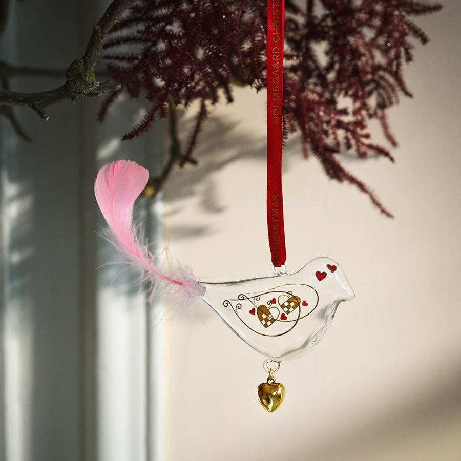 Julefugl fra Holmegaard henger som julepynt med rosa fjær, gylne detaljer og dekorative hjerter
