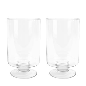To stilige stormlykter fra Christiania 1739, hver 35 cm høy, laget av klart glass med en robust fot, perfekt for å skape en koselig atmosfære hjemme eller på terrassen.