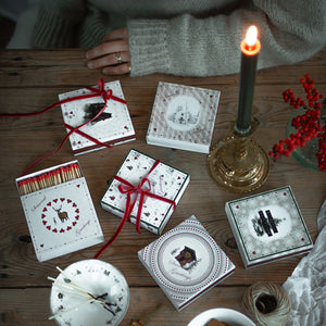 Dekorative fyrstikker fra Wik & Walsøe Julemorgen-serien arrangert sammen med julepynt, lysestake og juledekorasjoner