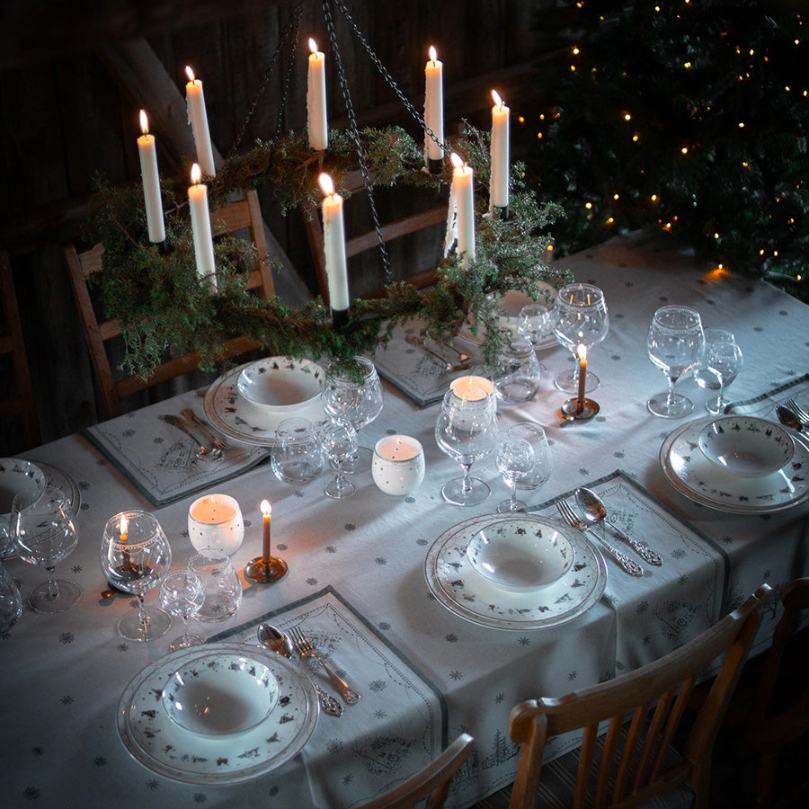 Festdekket julebord med Julemorgen akevittglass, servise og stemningsfulle lys