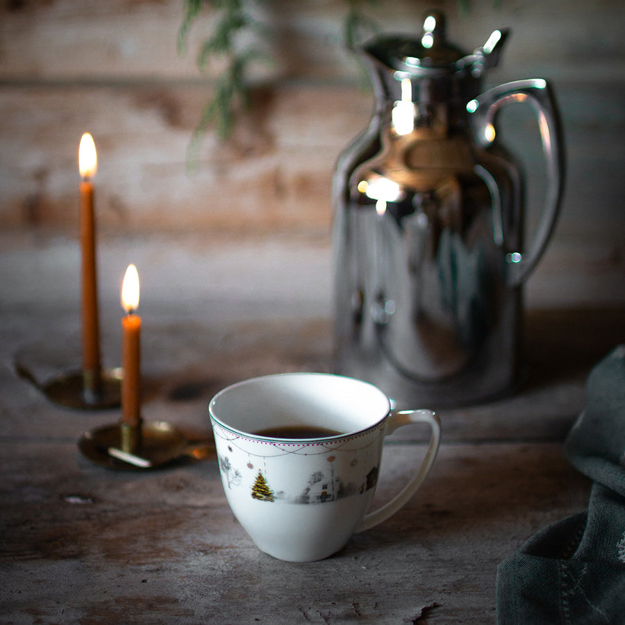 Wik & Walsøe Julemorgen kopp med kaffe på trebord ved siden av kaffekanne og tente stearinlys