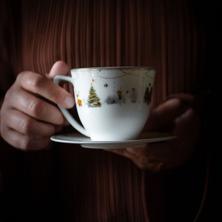 Wik & Walsøe Julemorgen Story kopp m/skål med juledekor, vist i bruk til en varm kaffestund