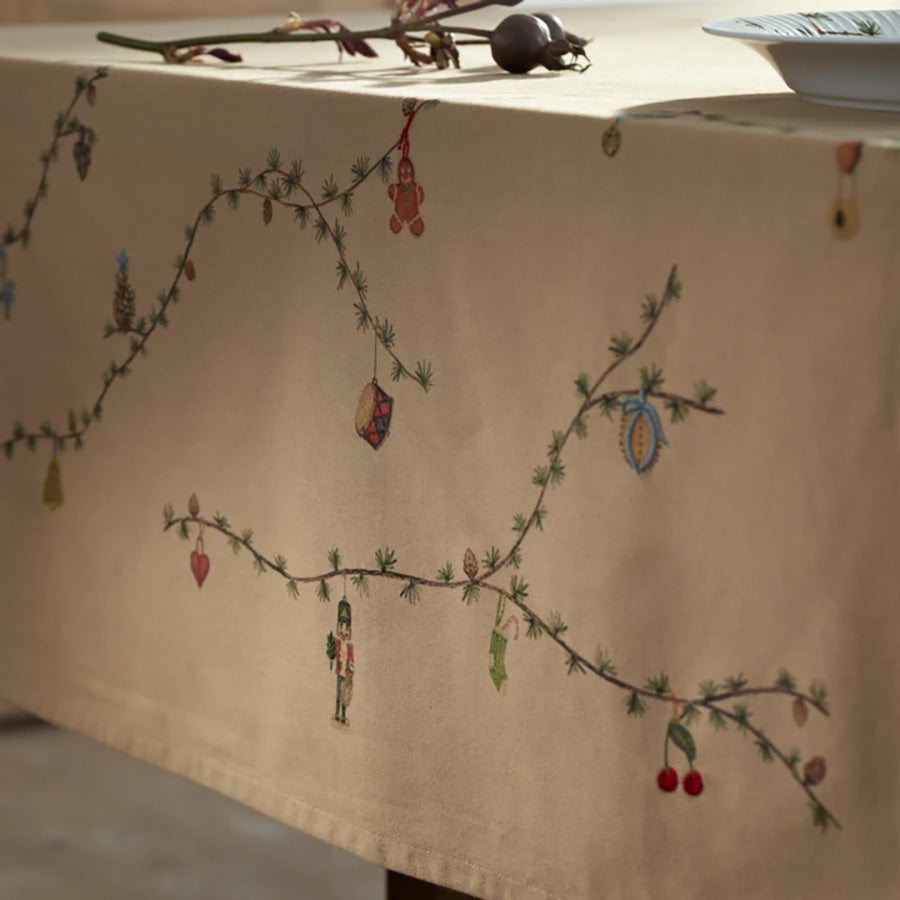 Detaljbilde av Kähler Hammershøi juleduk med håndmalt julemotiv, grangrener og fargerik julepynt