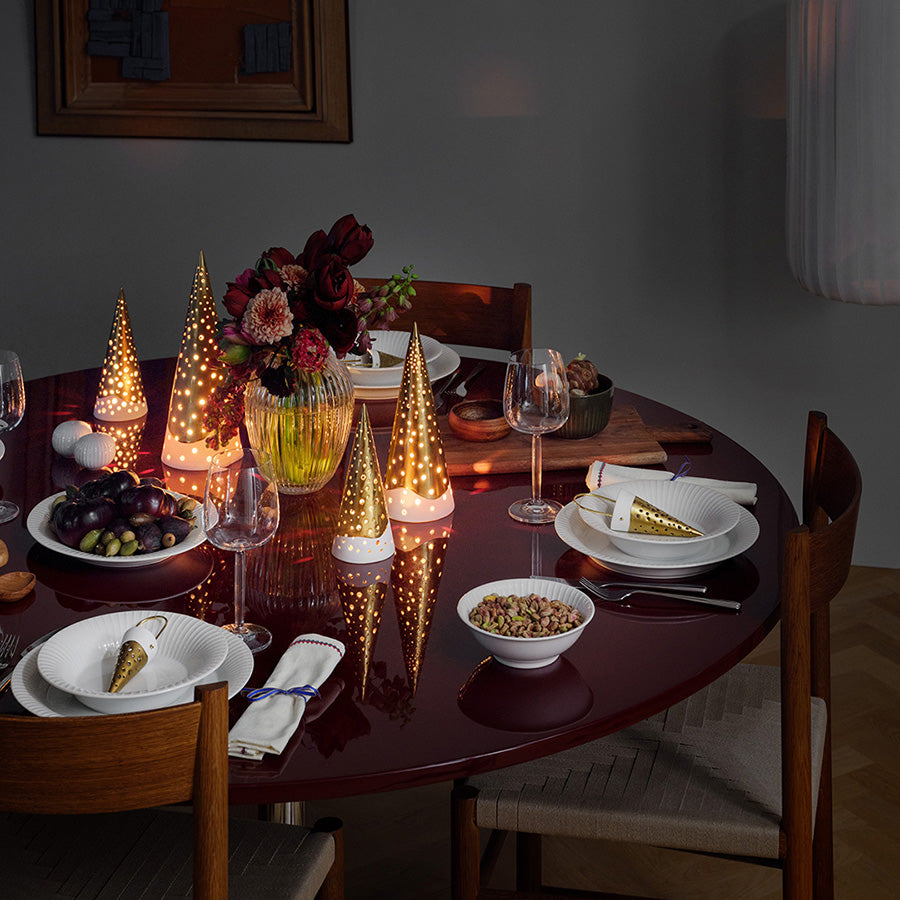 Stilfullt dekket bord med Kähler Hammershøi skål 16cm i hvit, sammen med andre dekorasjoner og belysning, perfekt for festlige anledninger.