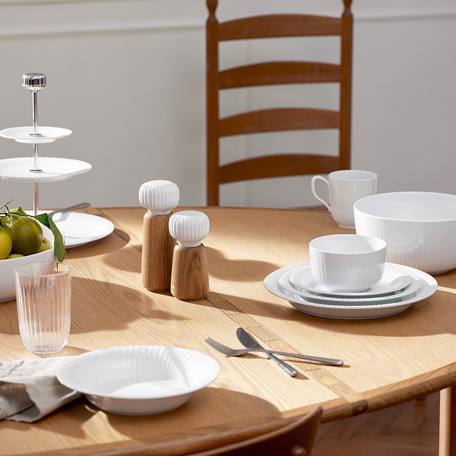 Kähler Hammershøi Kvern 18cm Hvit, kvernen plassert på et bord med hvitt servise, perfekt for middagsselskap.