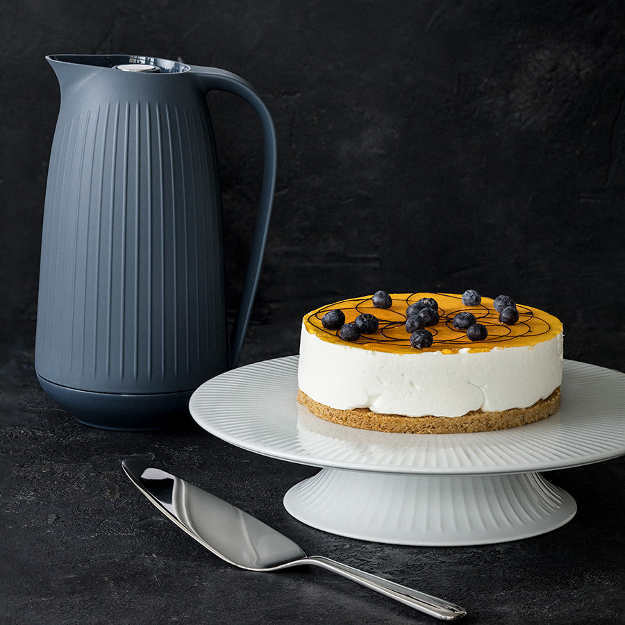 Kähler Hammershøi kakefat på stett 30 cm med en vakker kake dekorert med blåbær, passende for festlunsjer og spesielle anledninger.