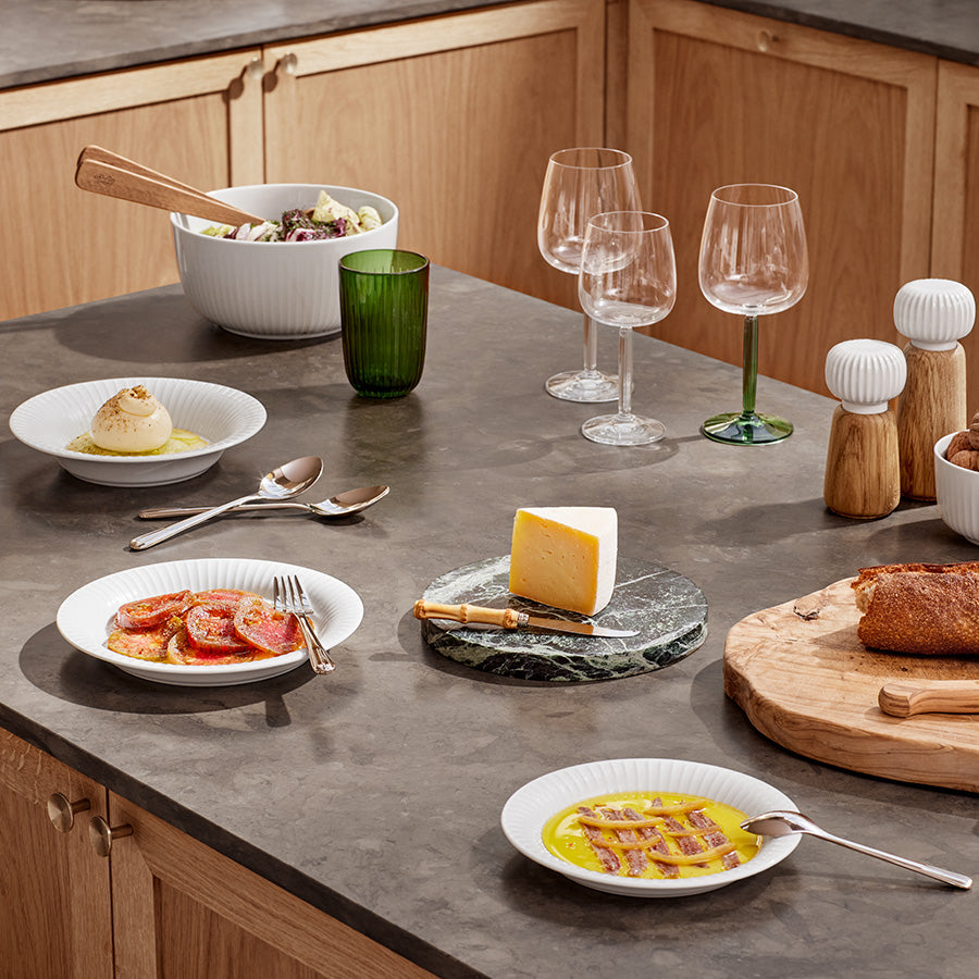 Kähler Hammershøi krydderkverner og serveringsutstyr på et moderne kjøkkenbord, setter fokus på god matopplevelse.