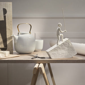 Kähler Hammershøi tekanne som står på et bord i et stilrent interiør, med rillede detaljer som fremhever den nordiske elegansen.