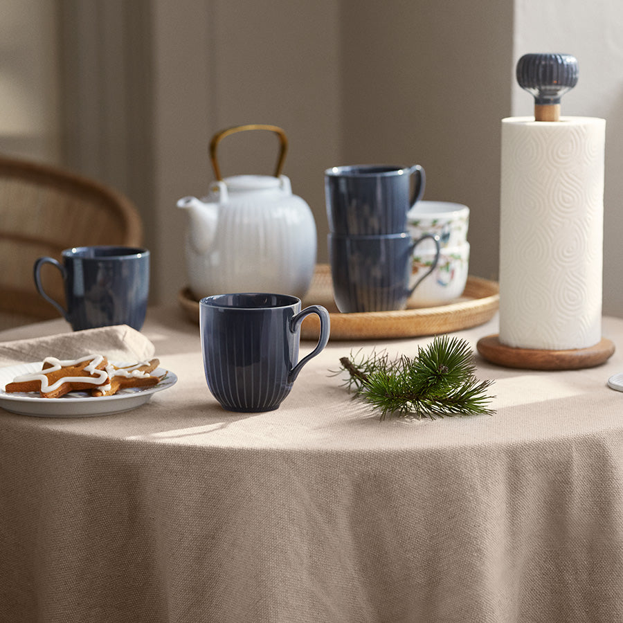 Kähler Hammershøi tekanne i hvitt porselen, kombinert med matchende kopper, for en helhetlig teopplevelse på bordet.