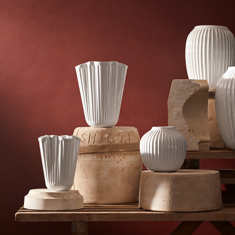 Gruppebilde av Kähler Hammershøi Unfold vase 16,5 cm hvit og andre vaser, viser variasjon i stil og form i et harmonisk miljø.