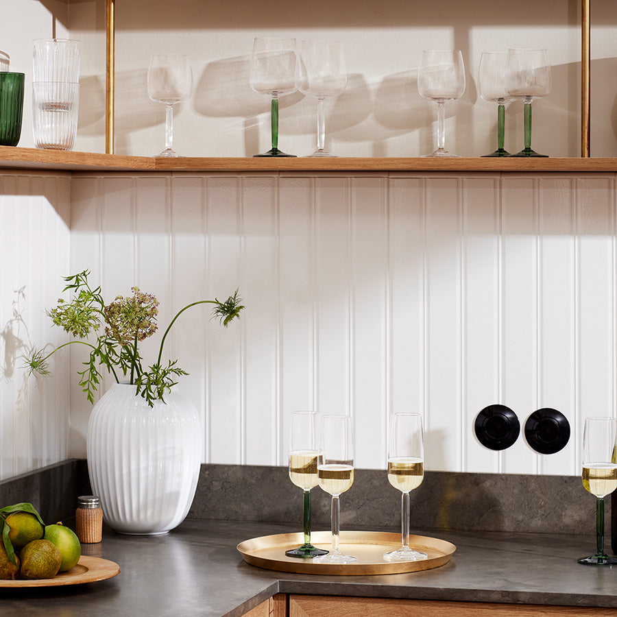 Kähler Hammershøi Vase 25,5 cm i hvit, plassert i moderne kjøkkeninteriør, som dekorativ vase for blomster og stilige glass.