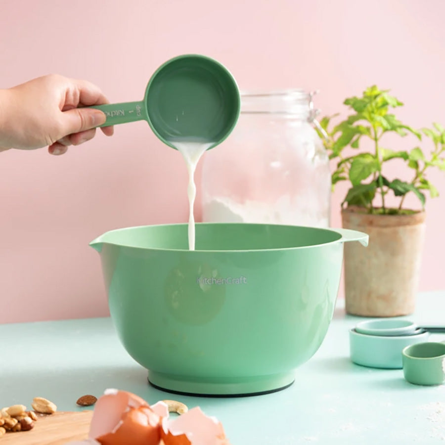 Grønn KitchenCraft-bolle fra bollesett brukes til å helle ingredienser under baking