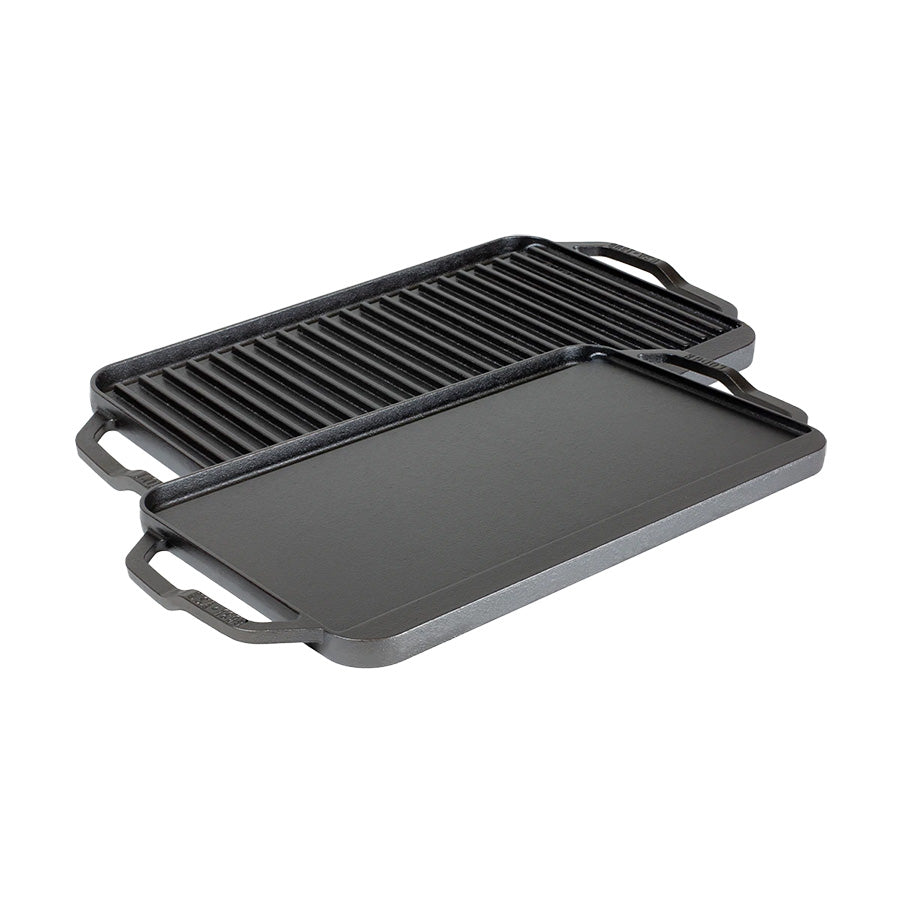 Vendbar steke- og grillplate i støpejern fra Lodge Cast Iron, med glatt og riflet overflate, ideell for grilling og steking av mat som egg, pannekaker, kjøtt og grønnsaker.