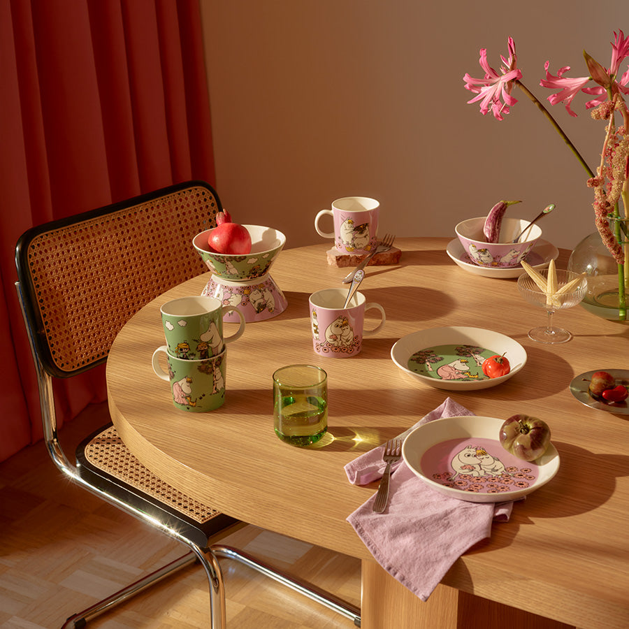 Mummi bolle sammen med Mummi-kopper på et bord dekket med blomster og grønnsaker, perfekt for servering.