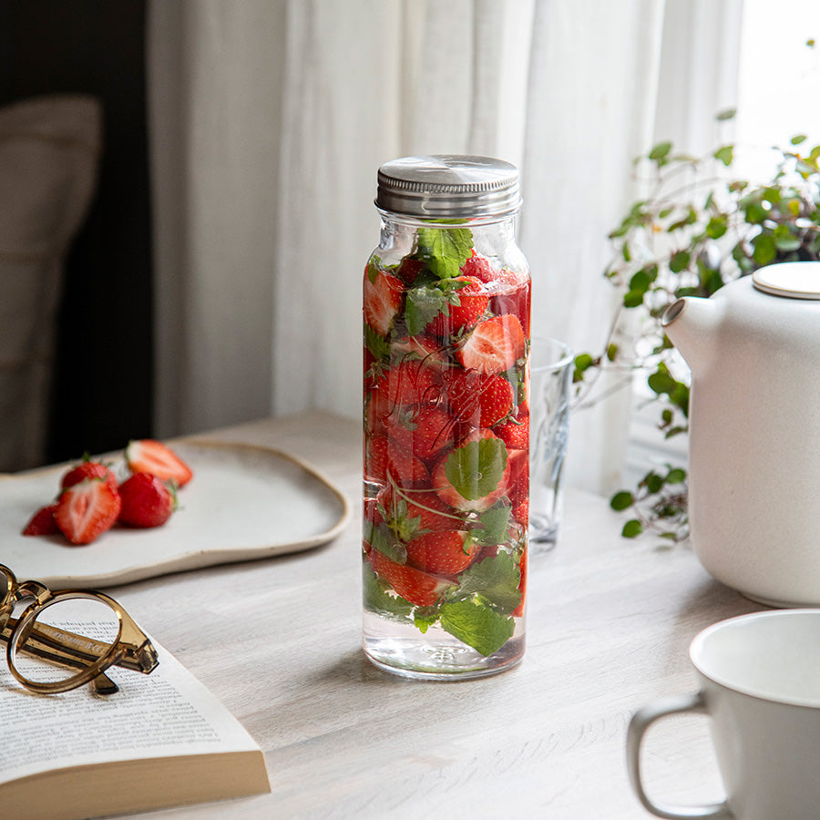 Norgesglasset flaske 0,7L med friske jordbær og mynteblader, perfekt for servering og oppbevaring av drikke.