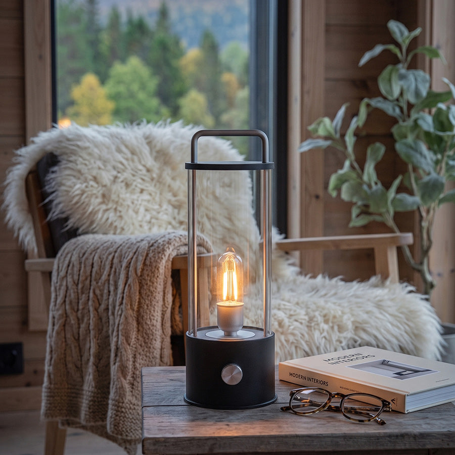 Ledlampe 31 cm i sort med varmt lys på sidebord i lun stue