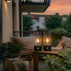 Ledlampe 31 cm i sort med varmt lys på et terrassebord i skumringen