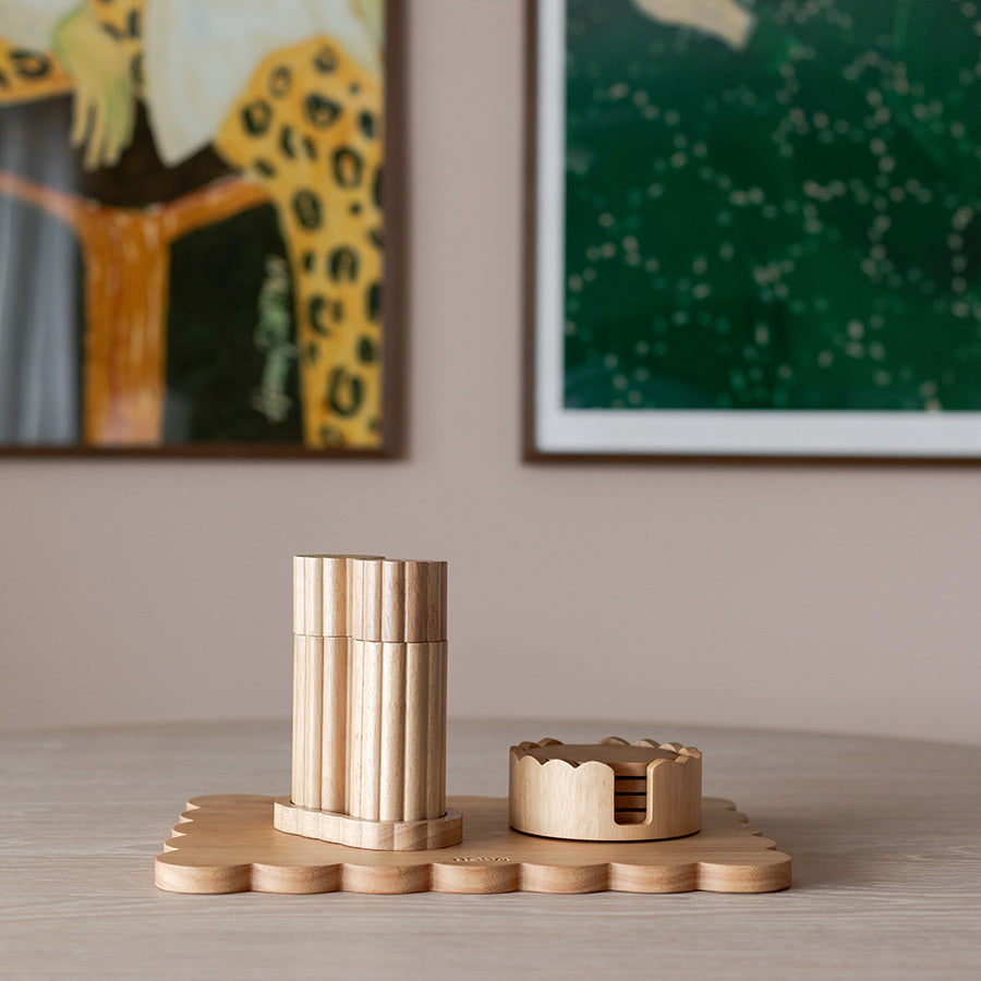 Coaster-holder med stilige treelementer plassert på et bord, perfekt for et moderne hjem.