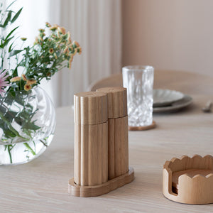 Salt og pepperkvern i tre fra Nova Billie, med blomster og glass på bordet.