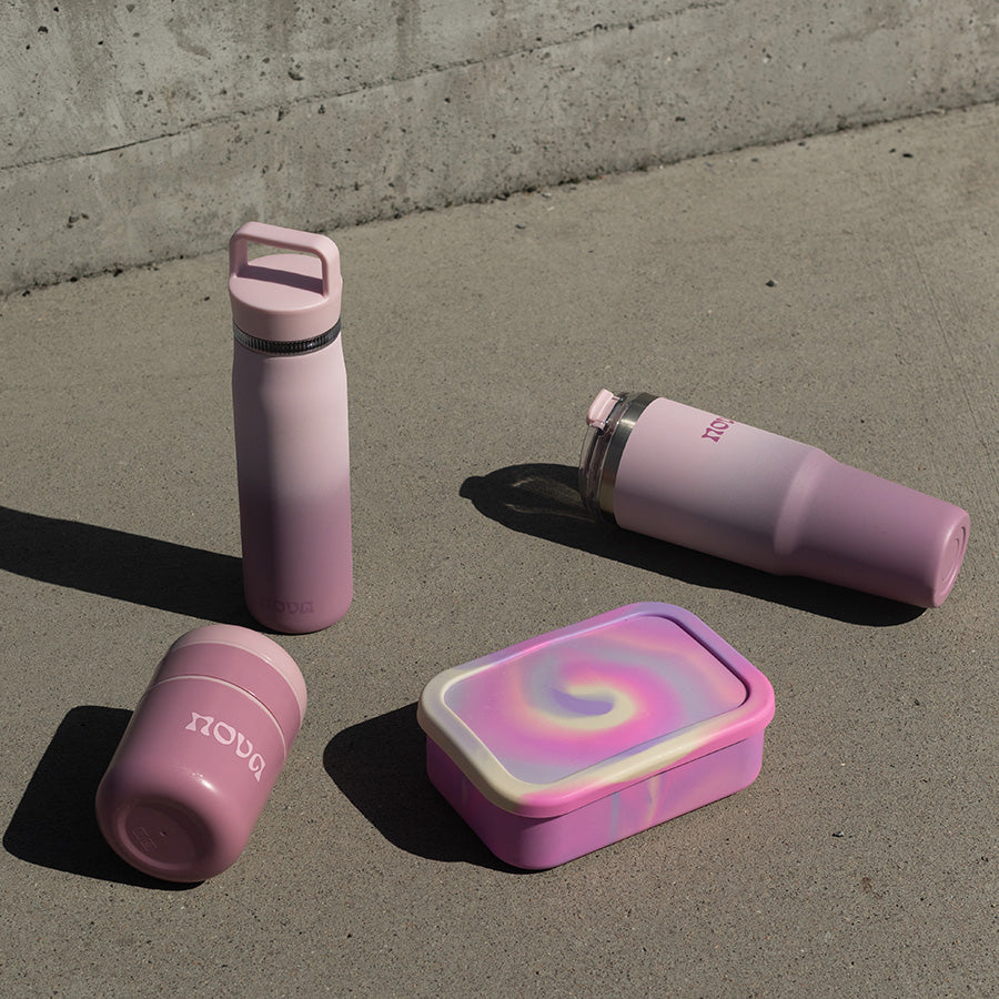 Seks forskjellige NOVA produkter samlet, inkludert en stilren rosa batikk matboks, ideell for bærekraftige måltider.