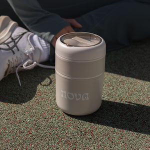 Nova mattermos plassert på bakken, med en sporty bakgrunn, perfekt for å ta med på turer.