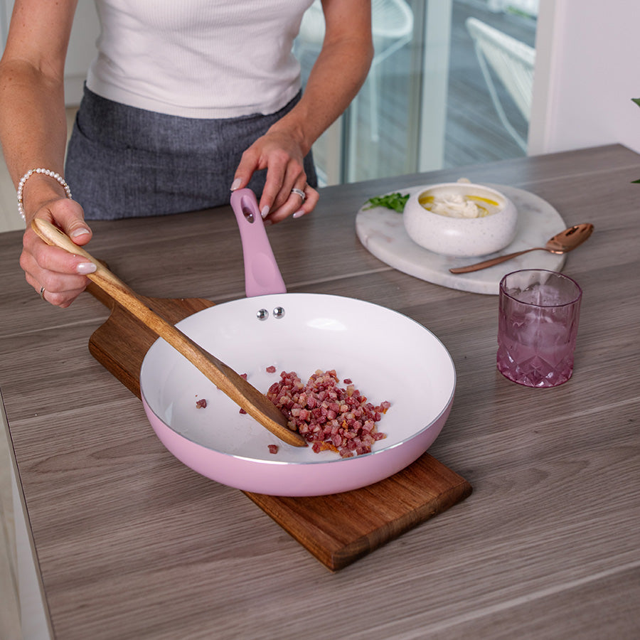 Fra toppen av en rosa stekepanne, med hvit innside, klar for matlaging.