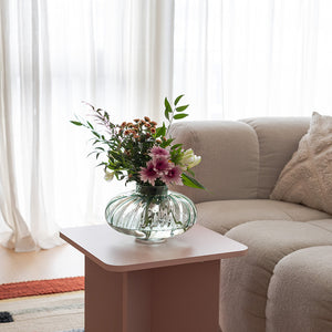 Nova Lottie vase med blomster, plassert på et bord i en stue, som tilfører en naturlig og frisk atmosfære i rommet.