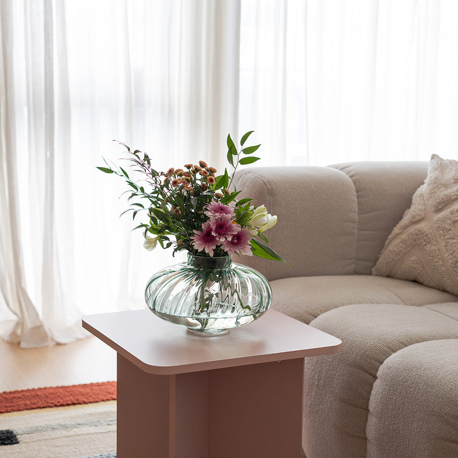 Nova Lottie vase med blomster, plassert på et bord i en stue, som tilfører en naturlig og frisk atmosfære i rommet.
