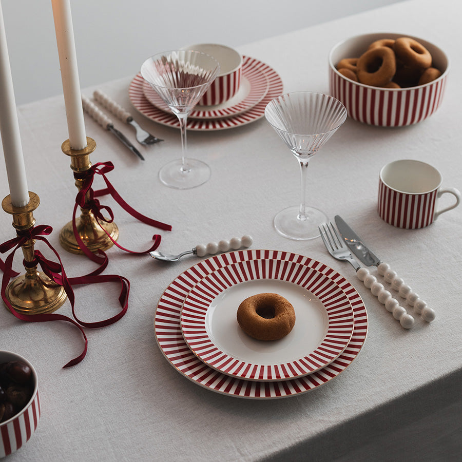 Stilrent bord med Nova Abby Bolle 12cm Rød m/Gull dekal og dessert, kombinert med elegant dekkede tallerkener og lysestaker.