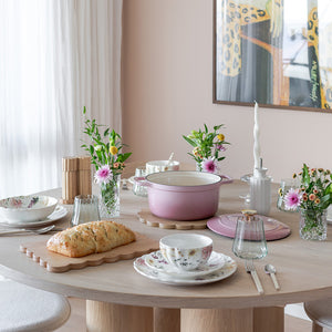 NOVA Nova Dynamic Støpejernsgryte 4,3L 24 cm Rosa – Støpejernsgryte i rosa emalje på fint dekket spisebord med blomster og servering