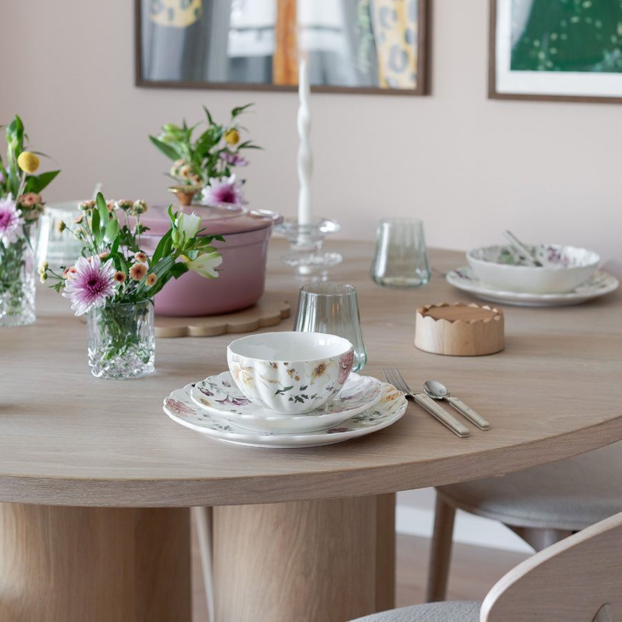 Elegant borddekk med Nova Lilly tallerken 26cm Villblomst, blomsterdekorasjoner, glass og bestikk, perfekt til måltider.