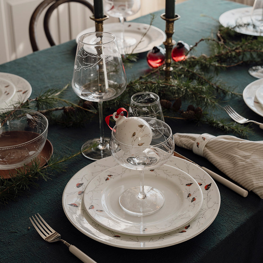 Cavaskål med dessert og gravert Dompap-motiv på juledekket bord