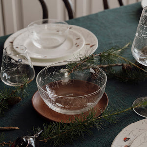 Klar Dompap glass bolle med gravert fuglemotiv, fylt med drikke og plassert på festdekket bord