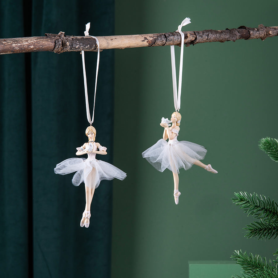 To hvite ballerinafigurer som hengepynt på en gren, inkludert Porsgrunds Bourrée i porselen